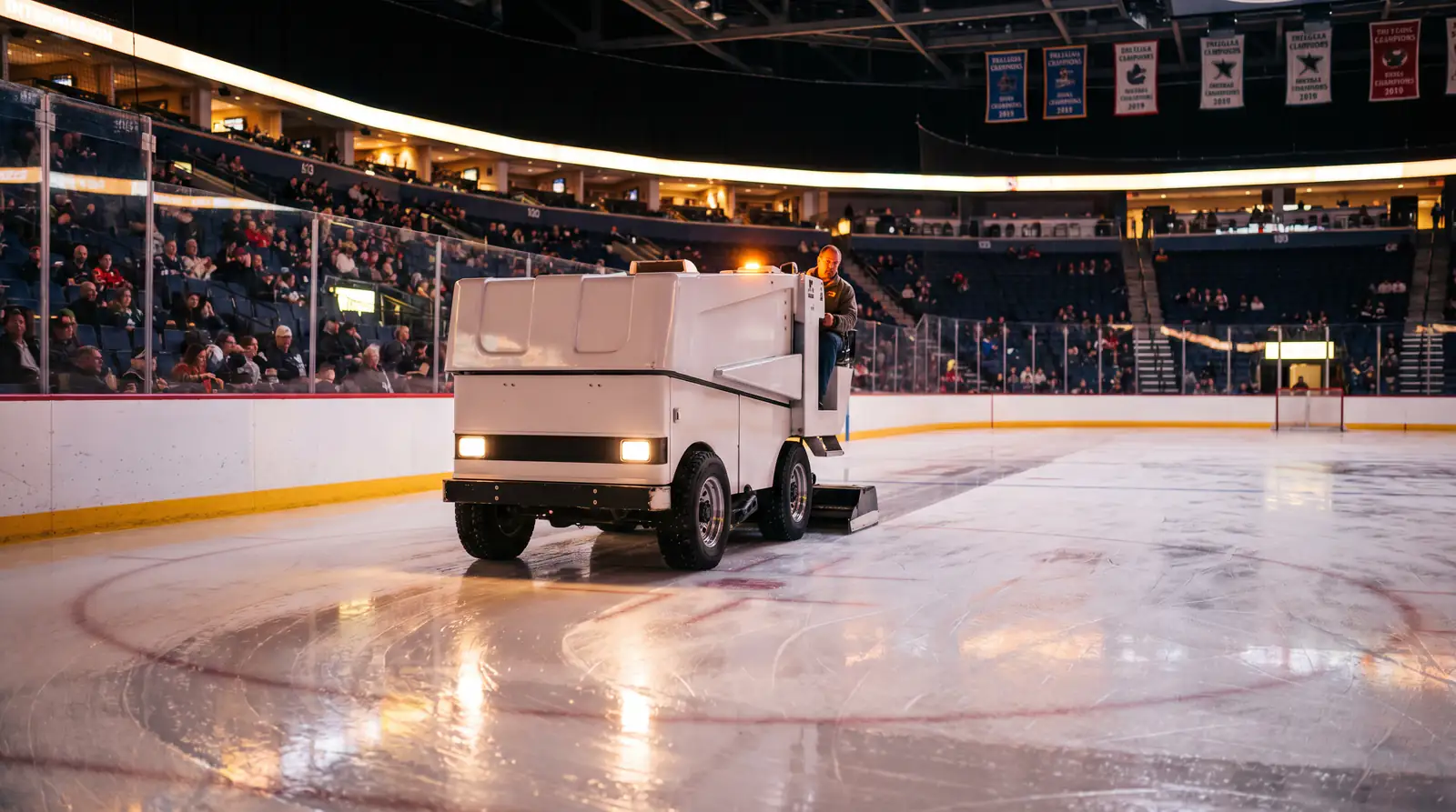 Zamboni resurfacing the ice during an NHL intermission with empty rink and arena lights