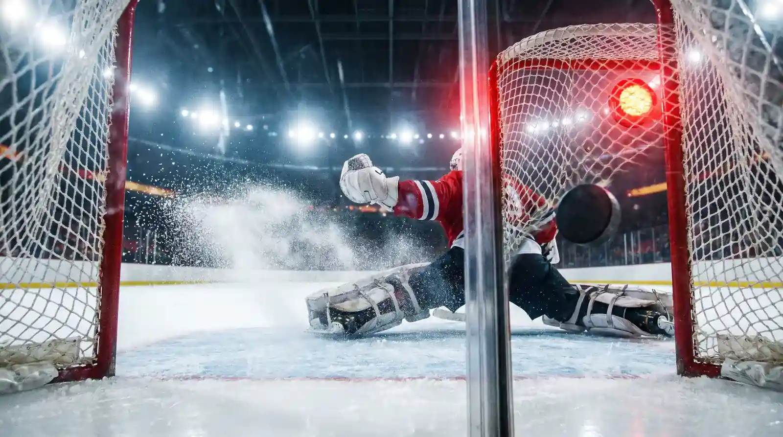 Ice hockey puck crossing the goal line past the goaltender during an NHL match